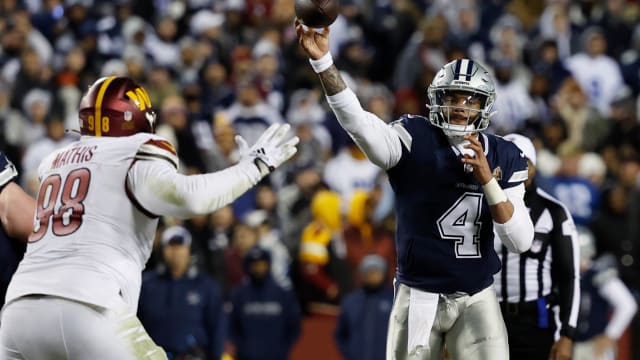Dallas Cowboys quarterback Dak Prescott (4) passes the ball as Washington Commanders defensive tackle Phidarian Mathis (98) defends during the fourth quarter at FedExField.